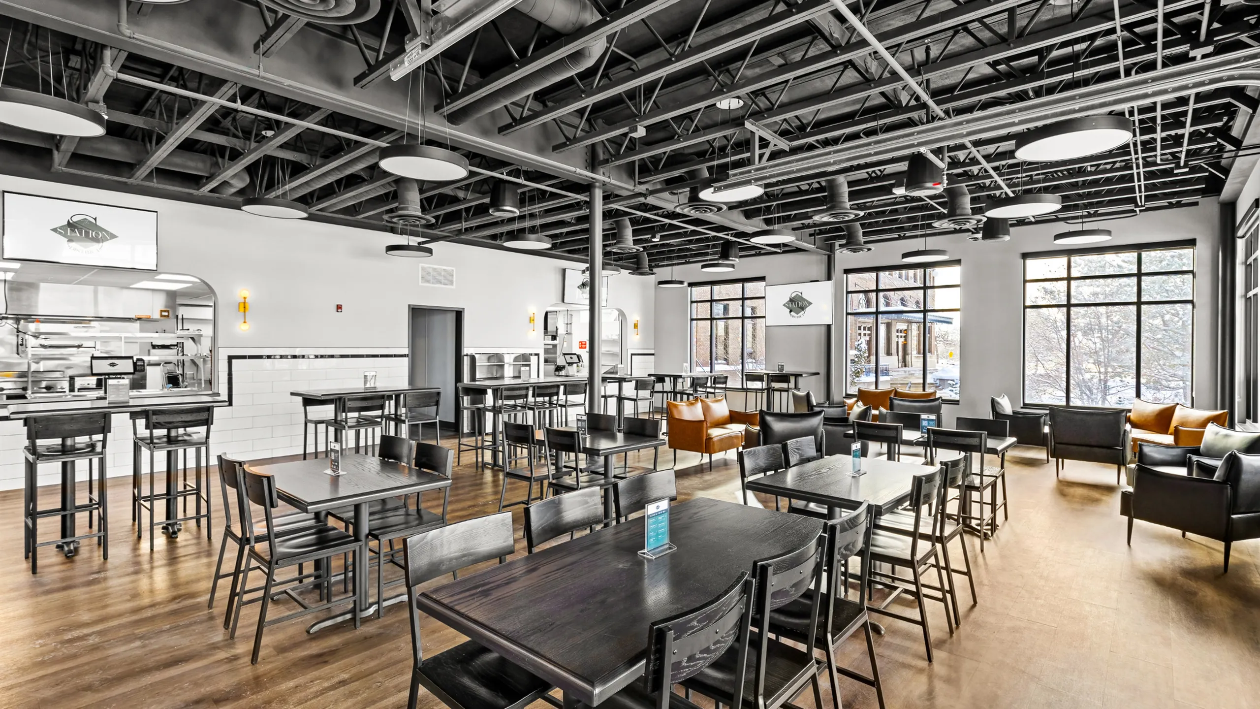 Modern cafe interior with industrial design, featuring open seating and natural light.