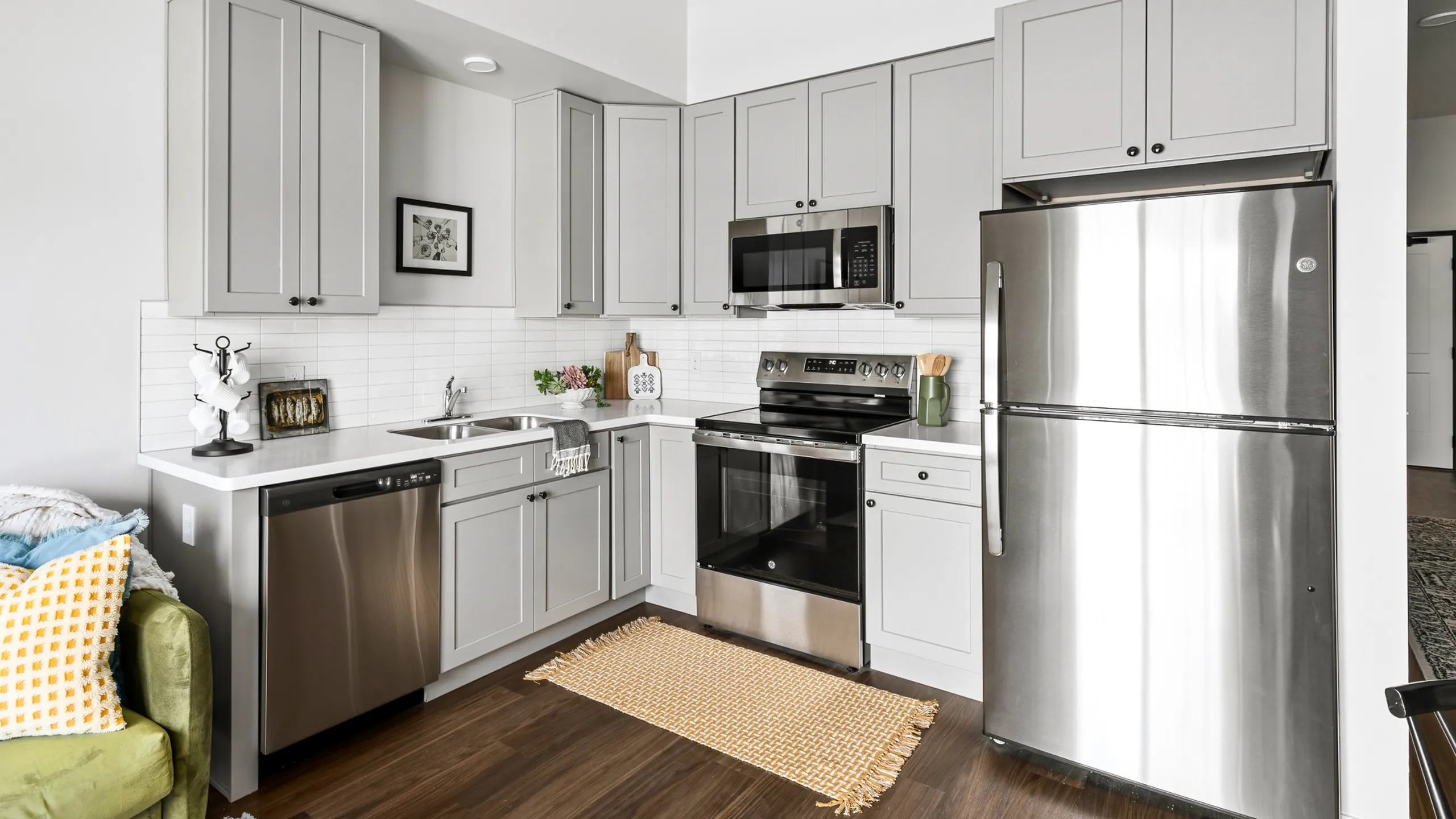 Contemporary kitchen with stylish grey cabinetry, stainless steel appliances, and elegant decor.