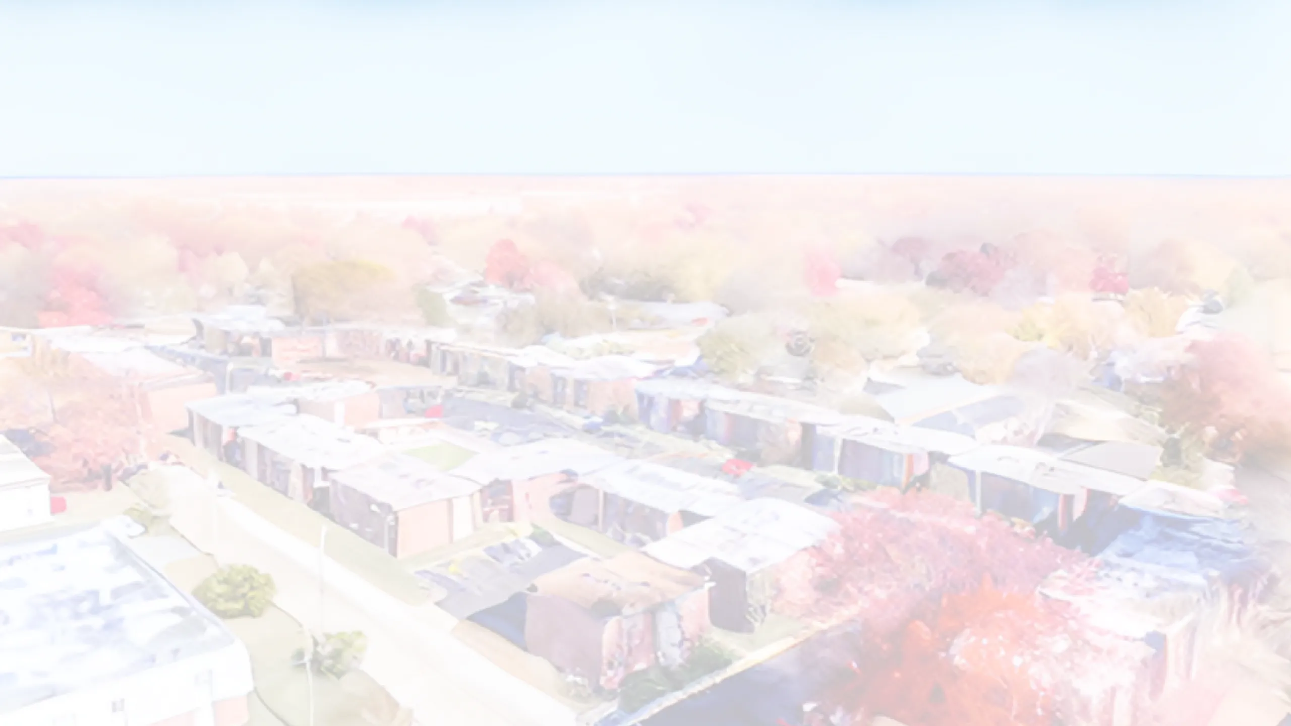 Serene aerial view of a residential community surrounded by vibrant autumn foliage, showcasing a peaceful neighborhood setting.