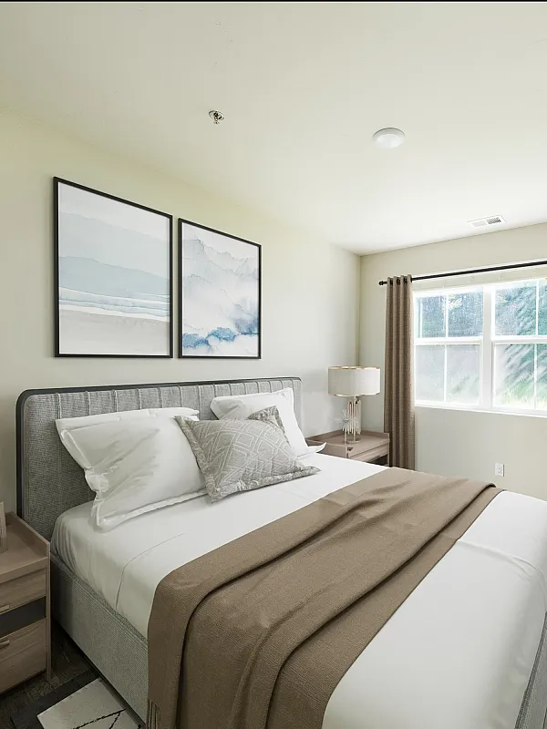 Bright and inviting bedroom with a cozy bed, stylish artwork, and a large window letting in natural light.