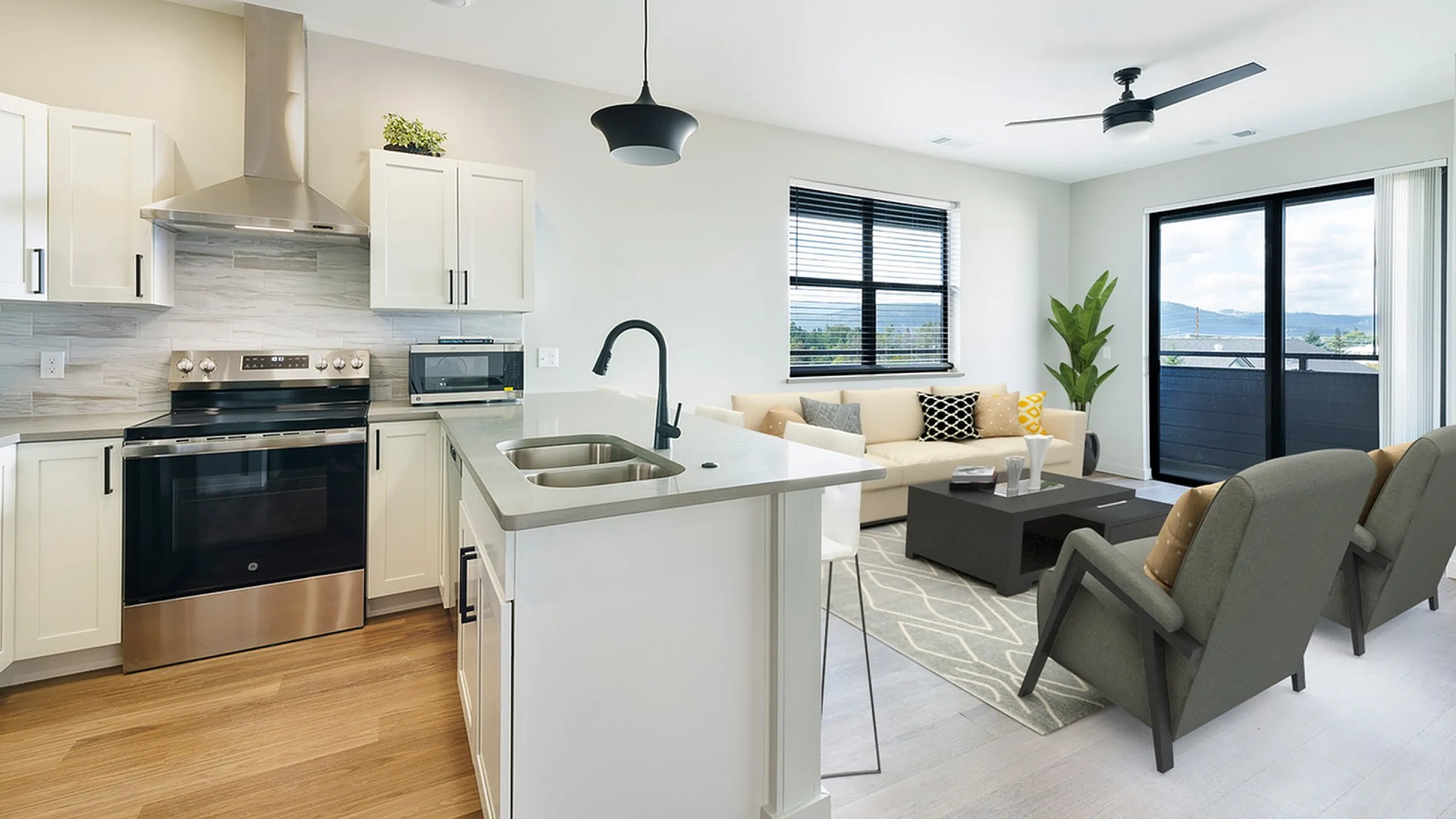 Modern open-concept kitchen and living room with sleek appliances, elegant countertops, and abundant natural light.