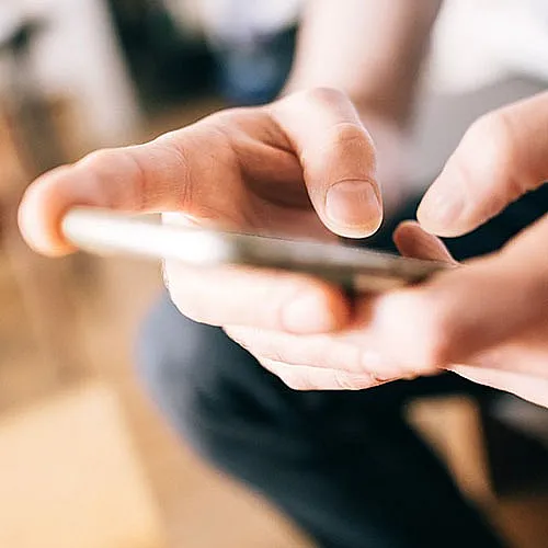 A photo of hands holding a cell phone