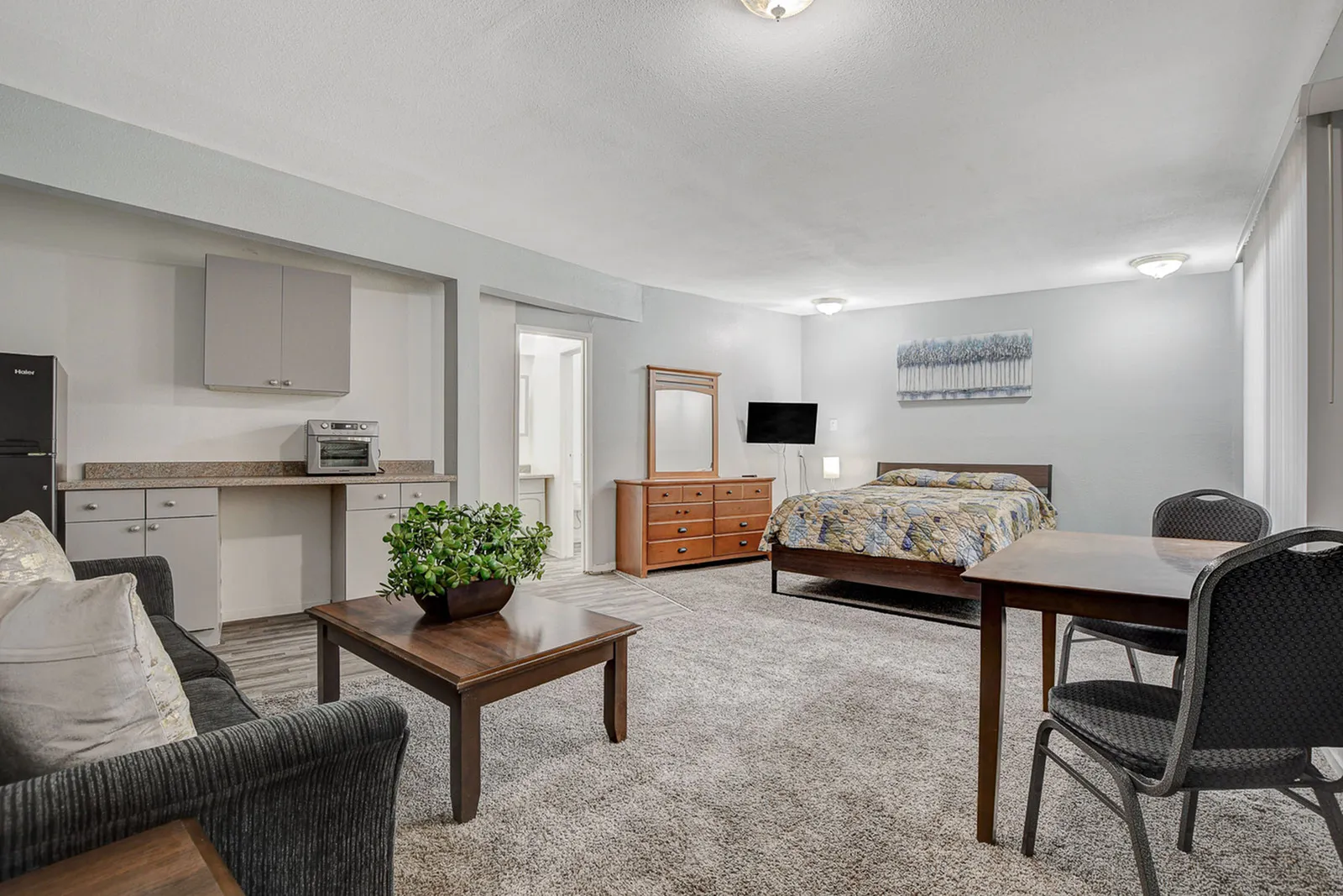 Inviting studio apartment with an open layout featuring a comfy bed, cozy sofa, and practical kitchenette.