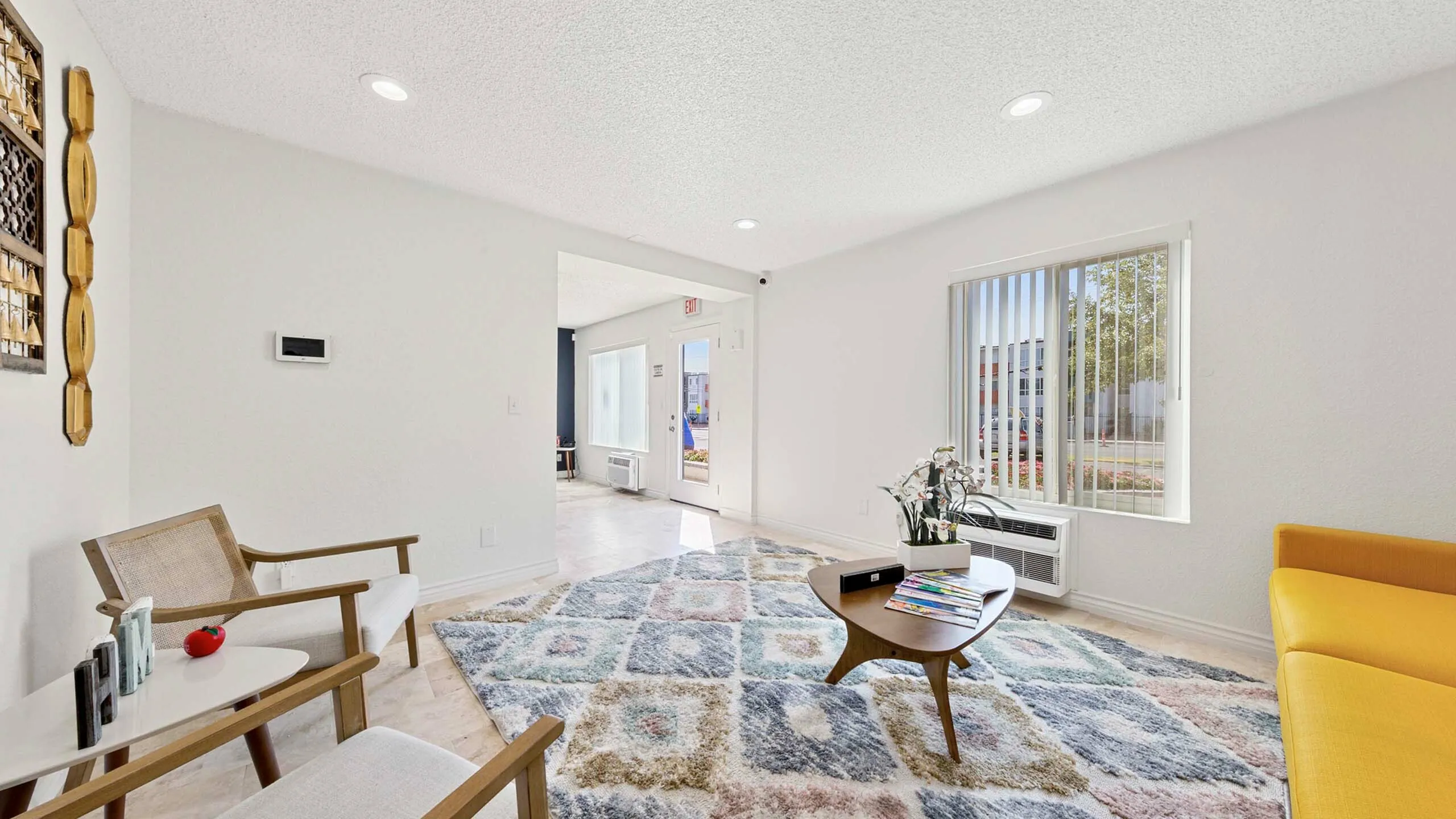 Bright and stylish living room with modern decor, featuring a cozy sitting area and a large window view.