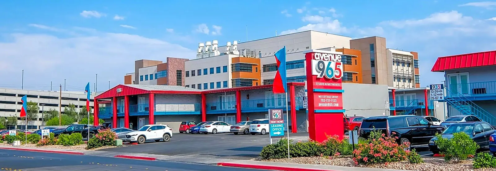 Vibrant exterior of Avenue 965 Studio Apartments with colorful modern design and ample parking space.