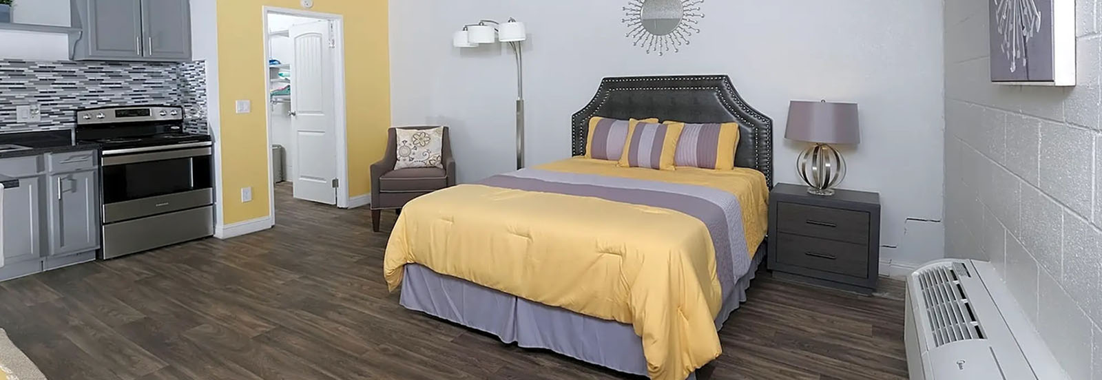 Inviting studio apartment with a comfortable bed, stylish kitchenette, and warm decor.