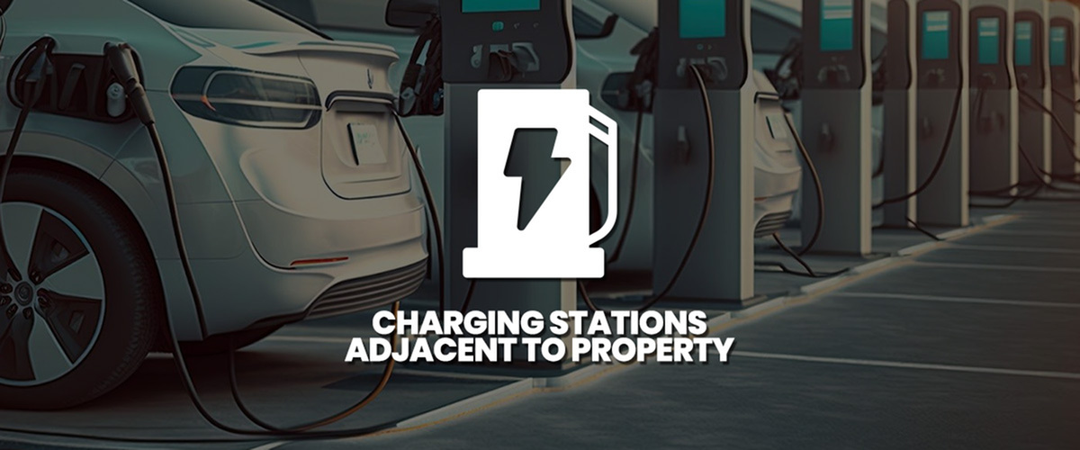 Modern electric vehicle charging stations adjacent to residential property, highlighting sustainability and convenience.