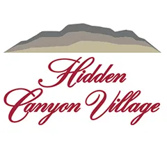 Elegant logo of Hidden Canyon Village with stylized script and a silhouette of a canyon landscape.