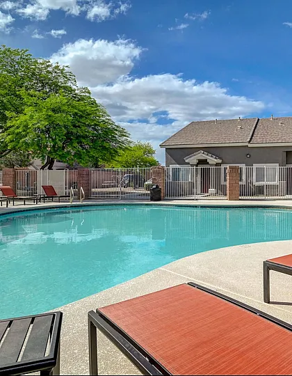 Inviting outdoor pool area with comfortable lounge chairs and lush greenery, perfect for relaxation and leisure.