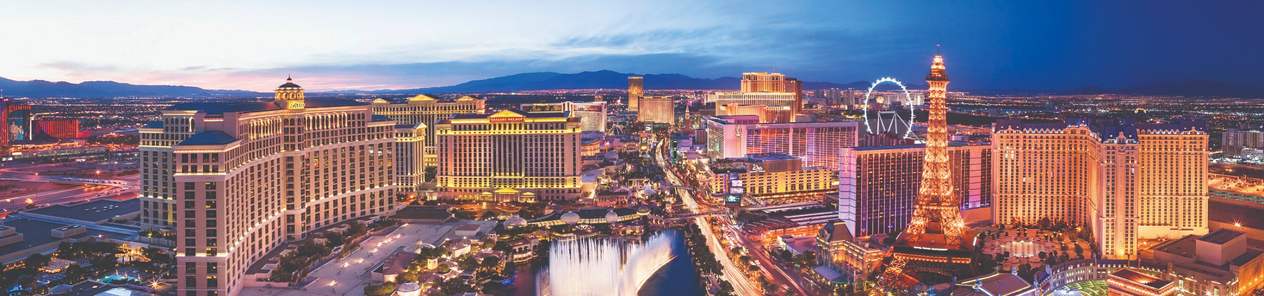 Vibrant panoramic view of a dazzling cityscape at dusk, showcasing illuminated landmarks, electric lights, and iconic architecture creating a mesmerizing skyline.