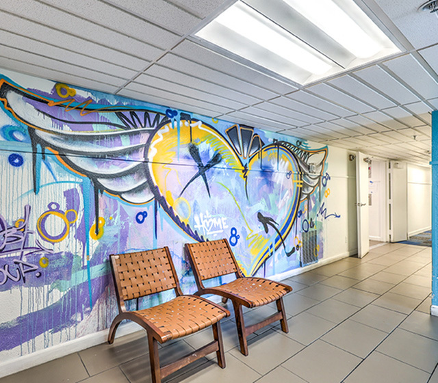 Vibrant lobby featuring eye-catching graffiti art with a colorful heart design and stylish seating.
