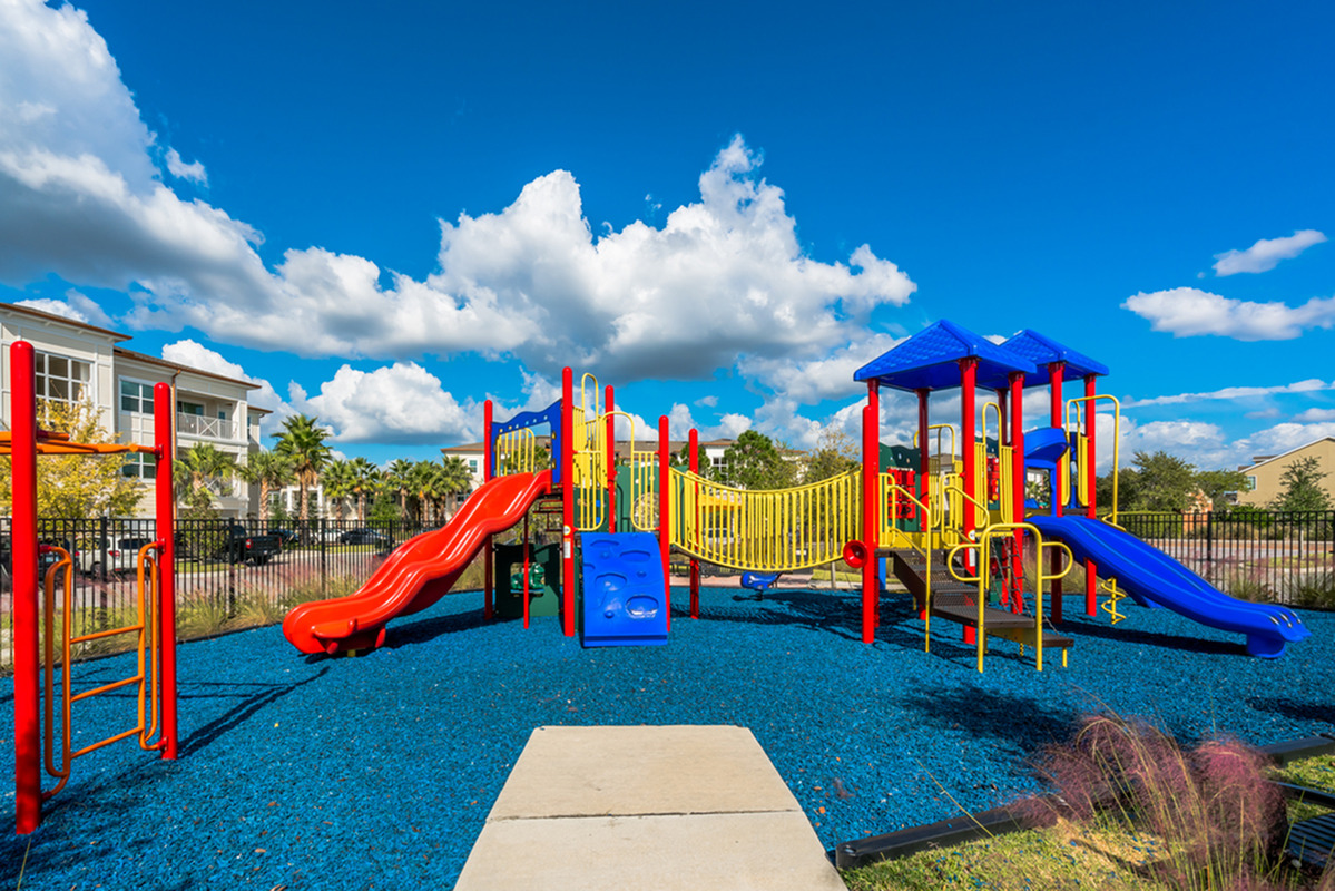 View of Playground, Showing Playground Equipment, Monkey Bars, and Slides at The Marq Highland Park Apartments in Tampa