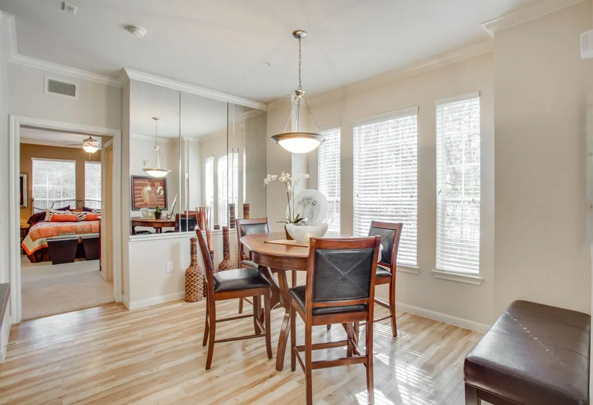 View of Dining Area with Hanging Light, Plank-Wood Flooring, and Décor at Raveneaux Apartments