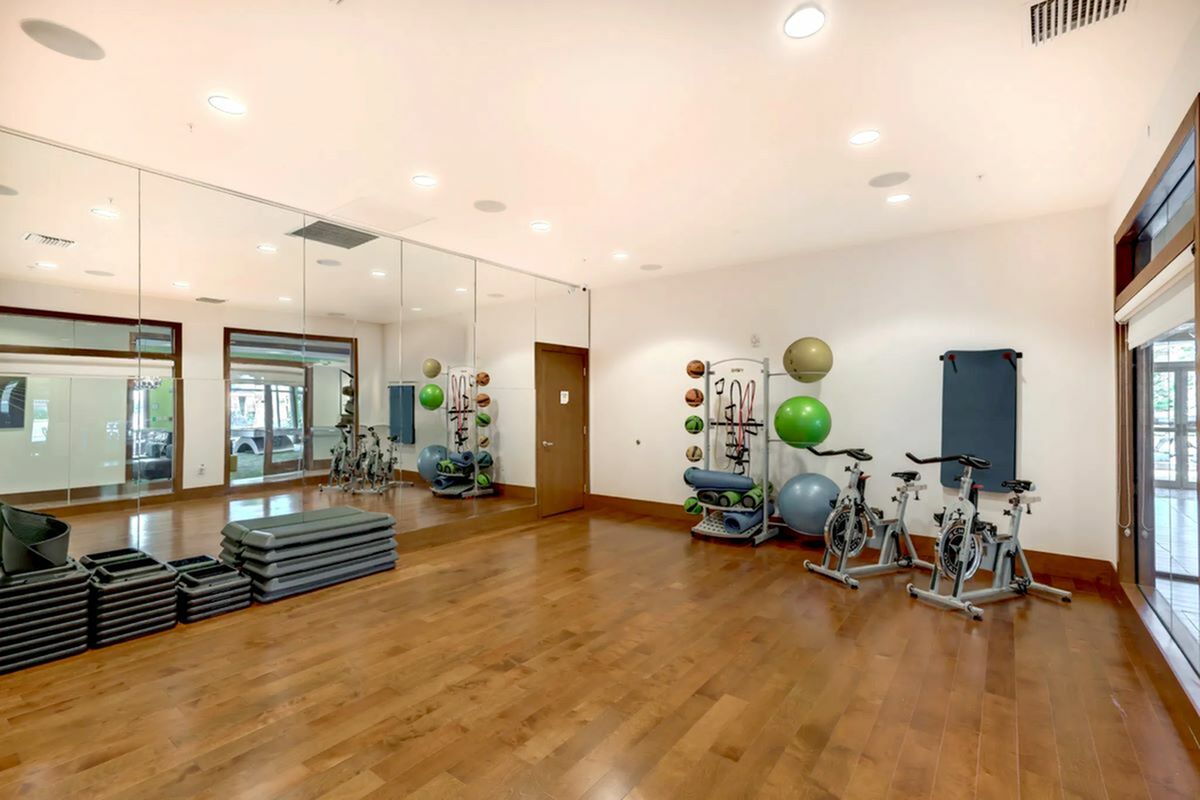 View of Yoga Space, Showing Stationary Bicycles, Exercise Balls, Medicine Balls, and Yoga Mats at The Marq Highland Park Apartments in Westchase