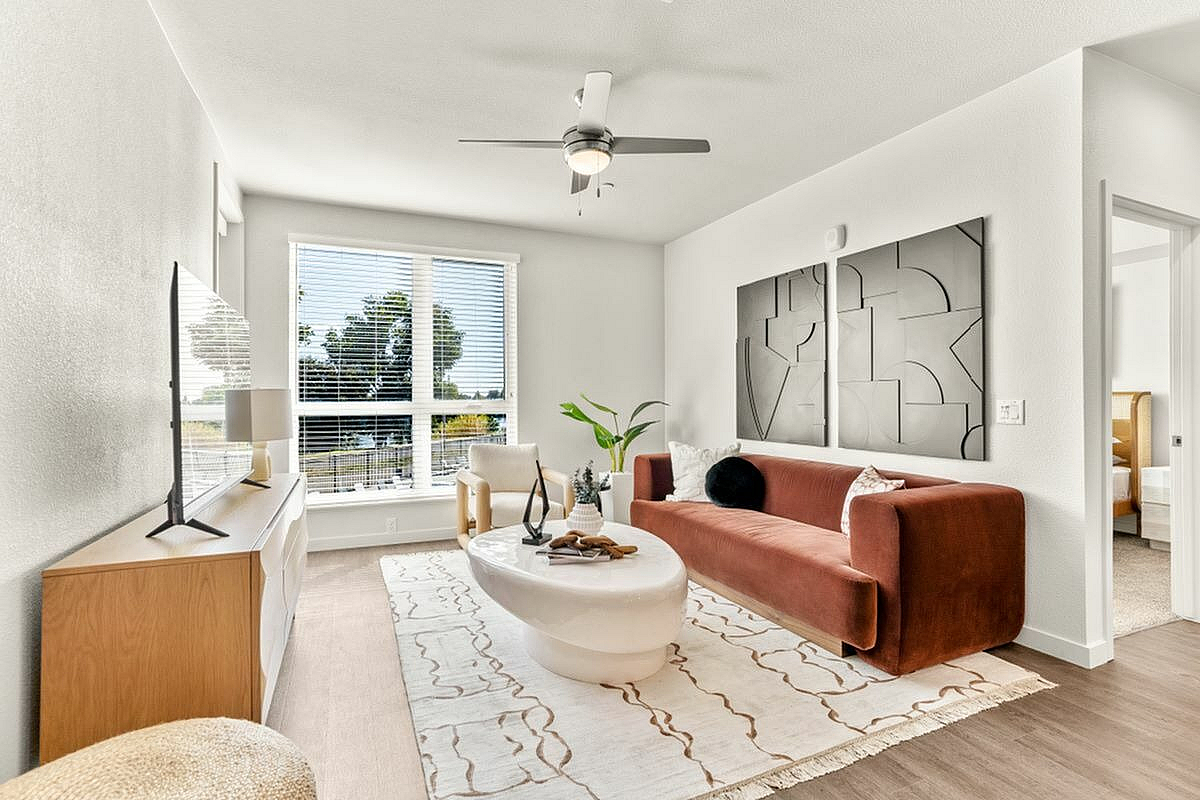 Bright living room with a modern sofa, unique coffee table, and large windows offering natural light at 805 Riverfront in Sacramento