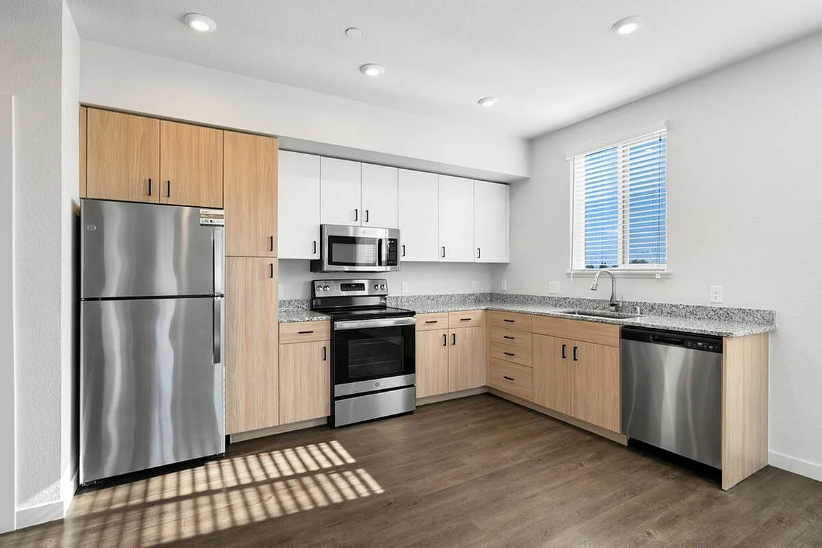 Bright, modern kitchen with stainless steel appliances, light wood cabinetry, and granite countertops at 805 Riverfront in Sacramento