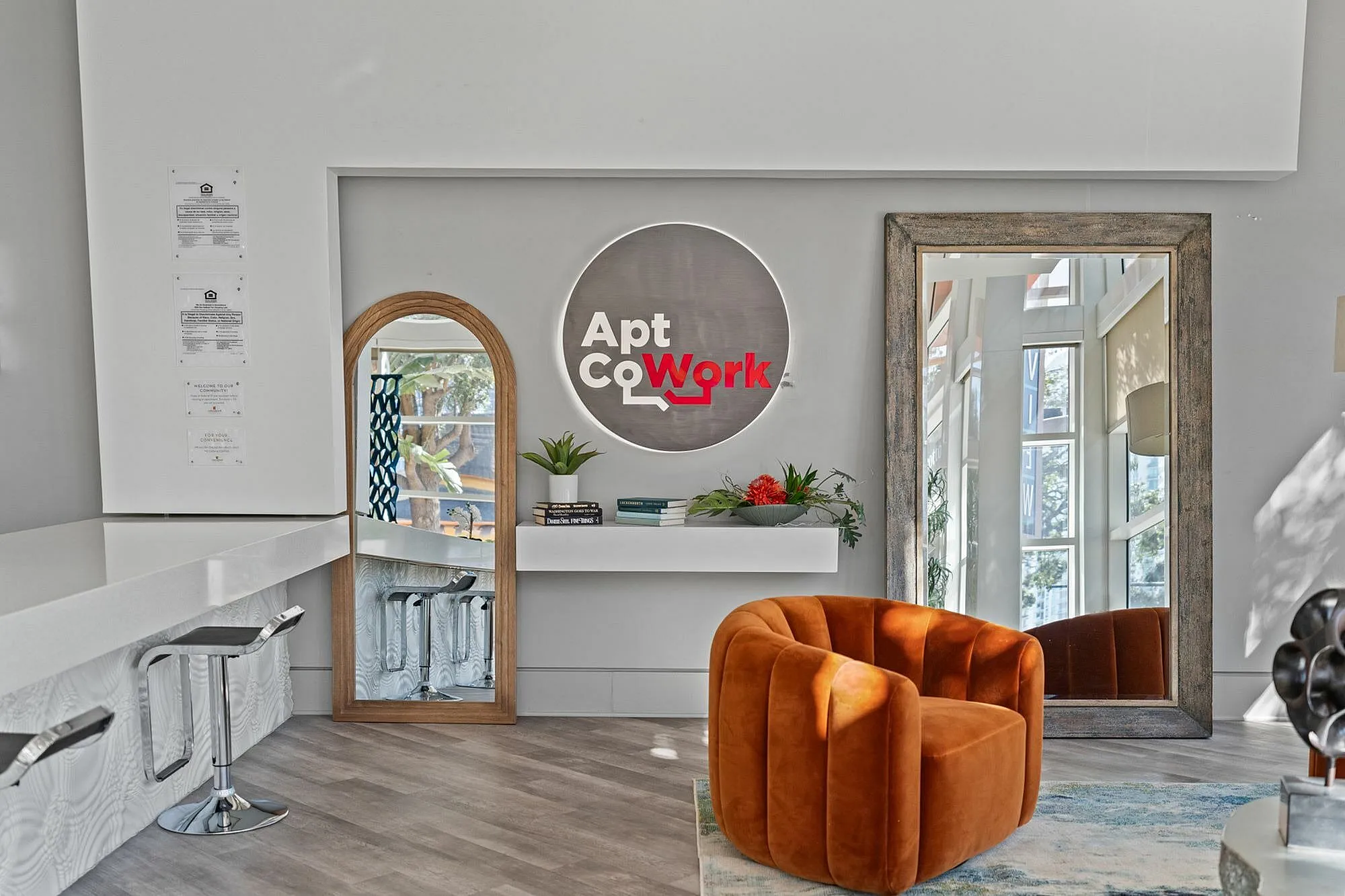 Modern co-working space featuring stylish seating, mirrors, and a welcoming sign.