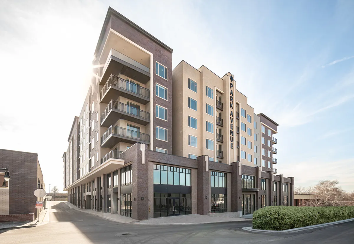 Contemporary apartment building in Salt Lake City with spacious balconies and modern design, bathed in natural sunlight.
