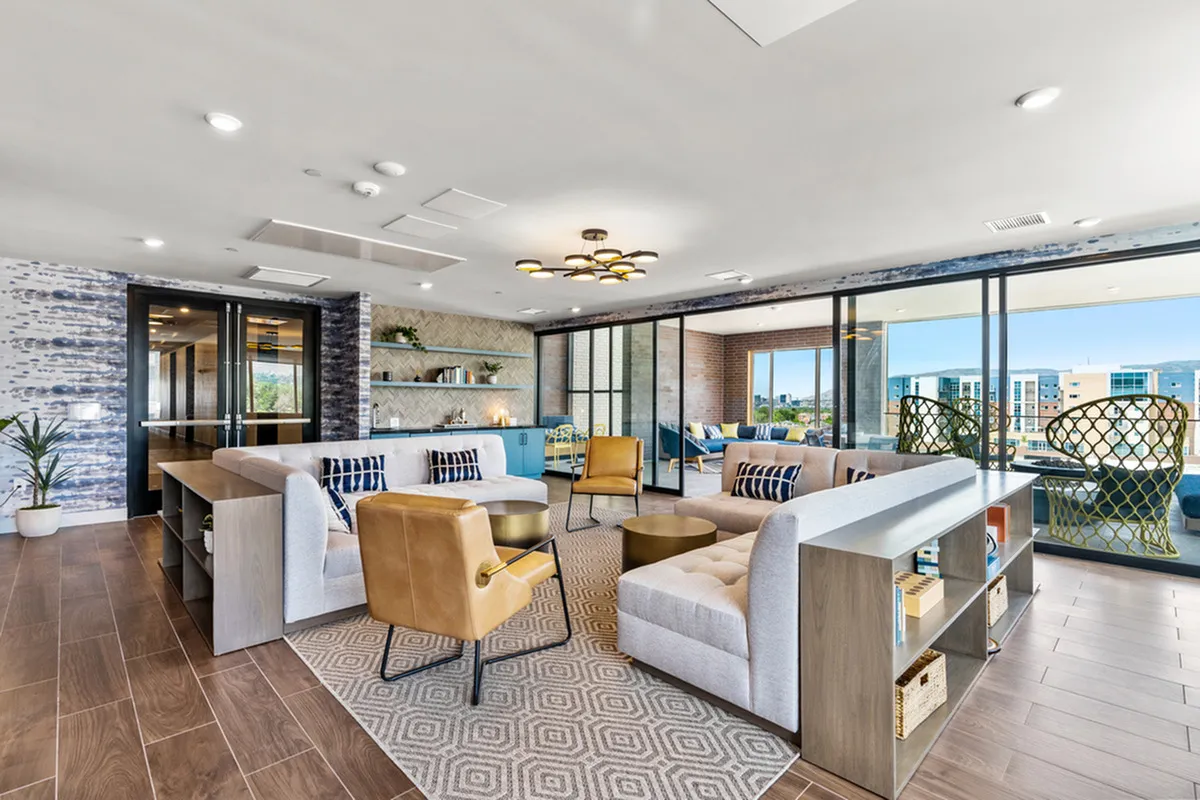 Contemporary lounge area with plush seating, modern decor, and expansive windows offering cityscape views.