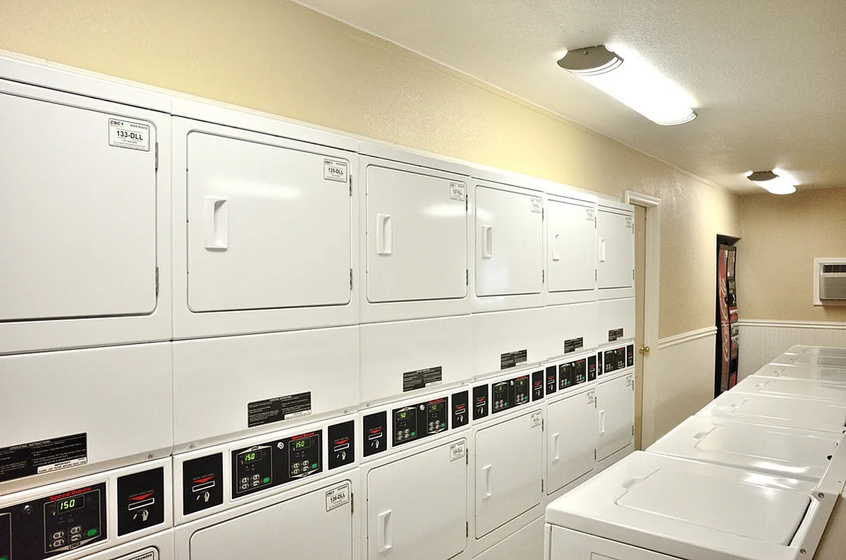 Modern laundry facility at Camelot in Yuma with abundant washers and dryers, bright lighting, and a welcoming atmosphere.