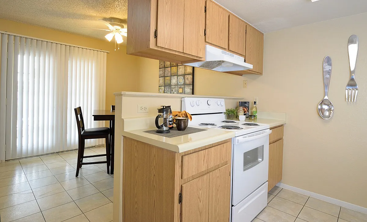 Inviting Camelot Apartment's kitchen with wooden cabinets, modern appliances, and charming dining area, ideal for cozy meals.