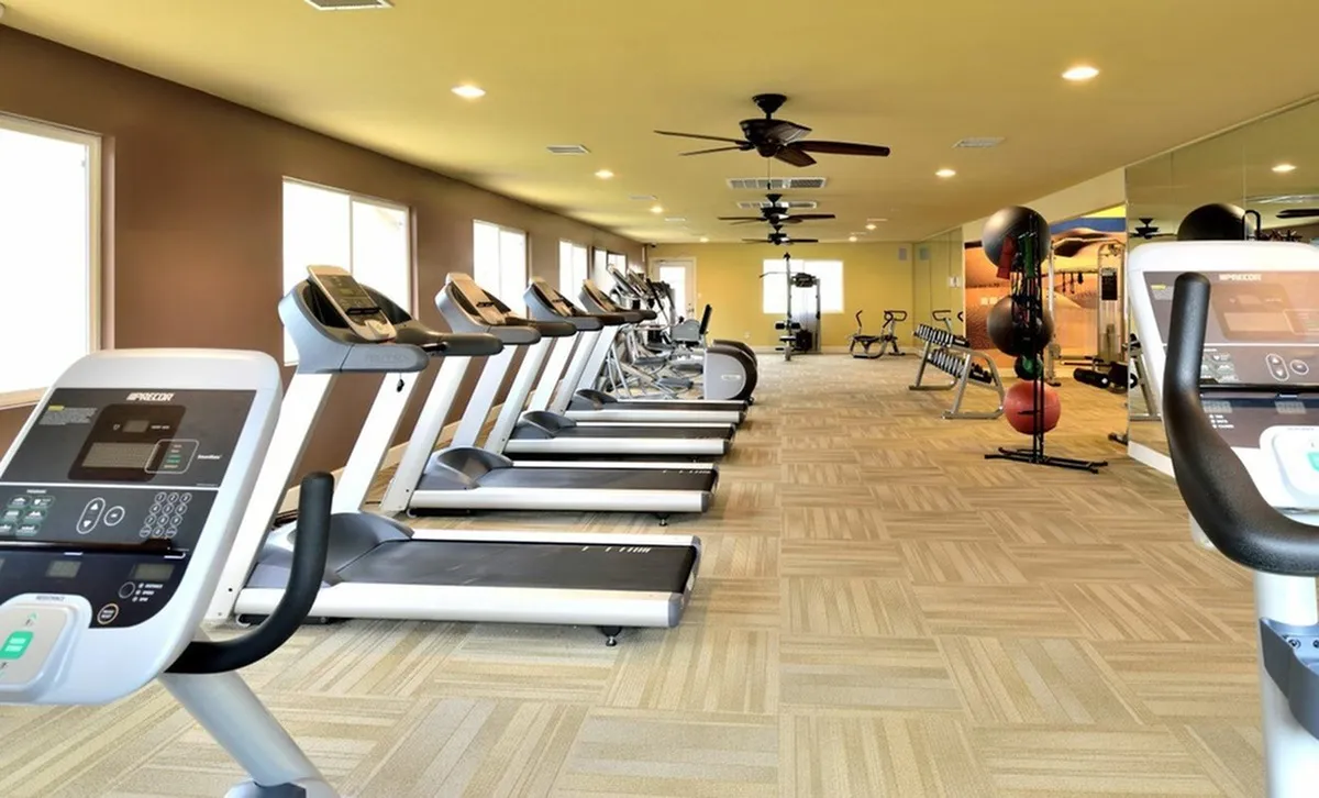 Spacious and modern gym with state-of-the-art fitness equipment, including multiple treadmills and training stations, ideal for a complete workout experience at Camelot Apartments in Yuma, Arizona.