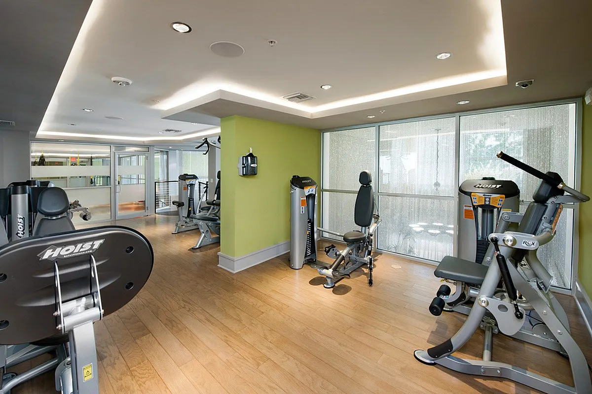 Modern fitness center at Cottonwood Bayview in St. Pete with state-of-the-art equipment, vibrant decor, and natural light through large windows.