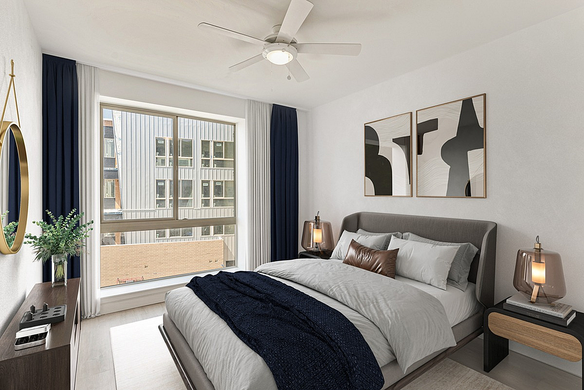 Elegant bedroom at Cottonwood Highland Apartments with cozy bed, modern decor, and large window inviting natural light.