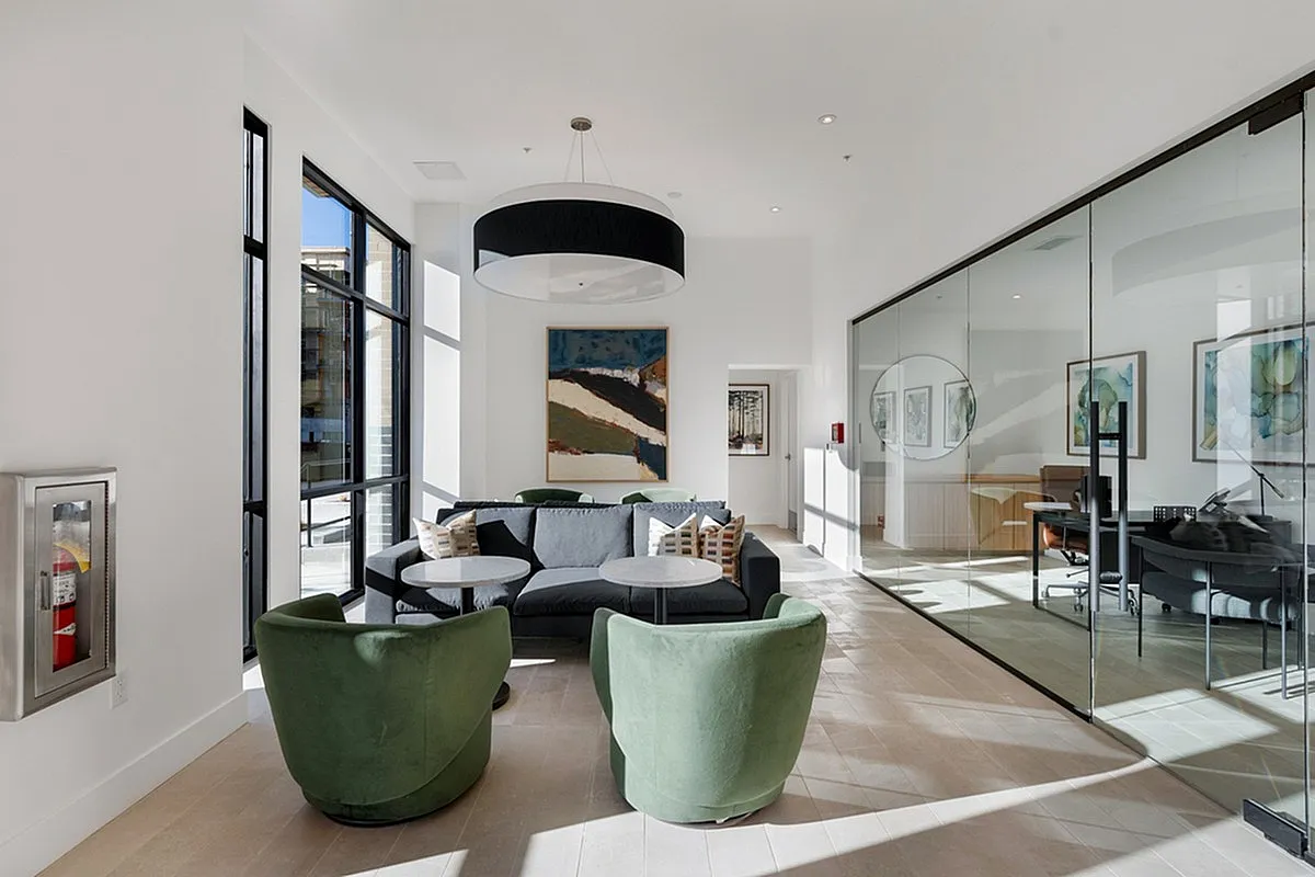 Modern and bright coworking space at Cottonwood Highland with sleek glass walls, cozy seating, and stylish artwork, perfect for relaxation and collaboration.