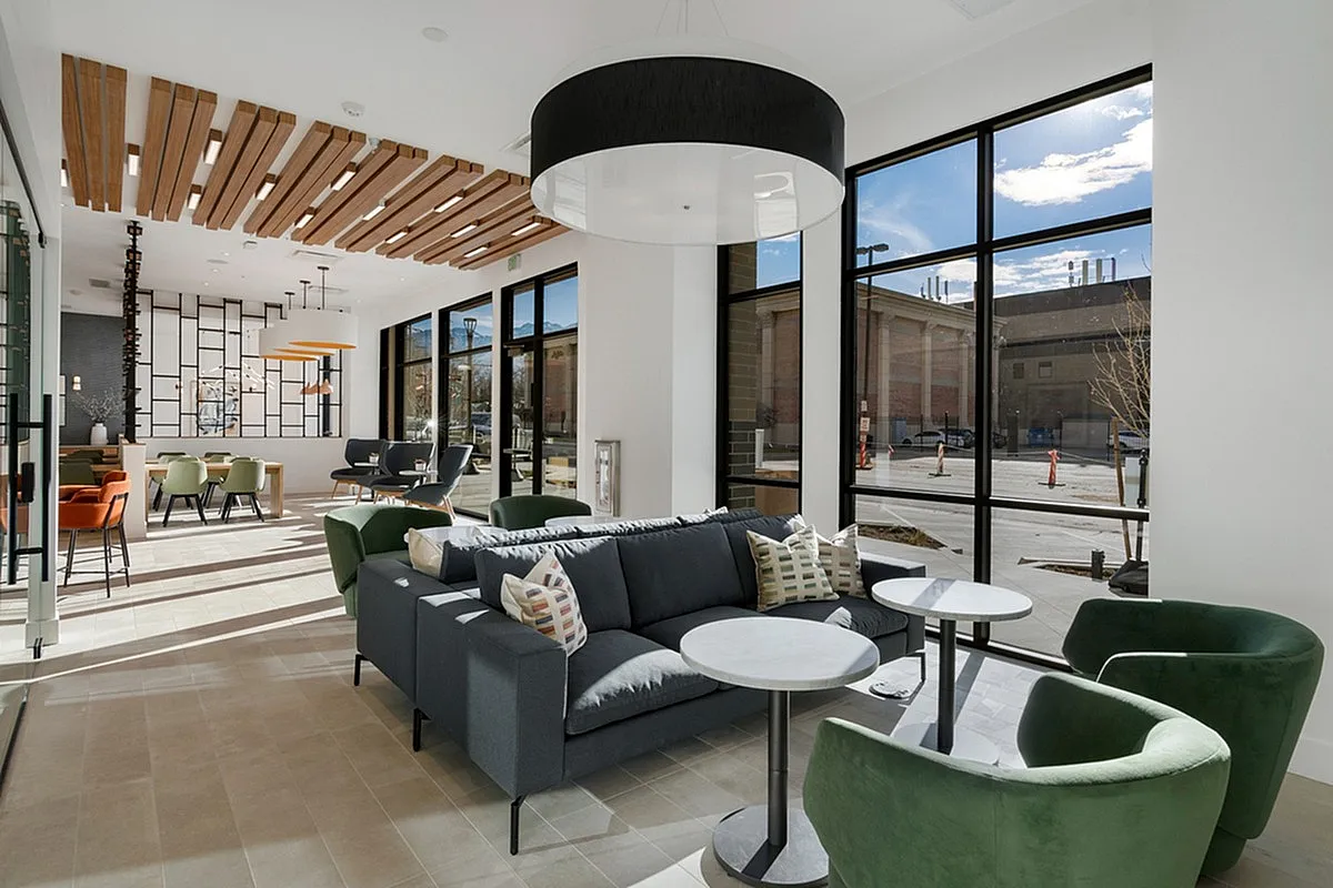 Modern and spacious coworking space, Apt CoWork at Cottonwood Highland with stylish seating, large windows, and elegant wooden ceiling accents.
