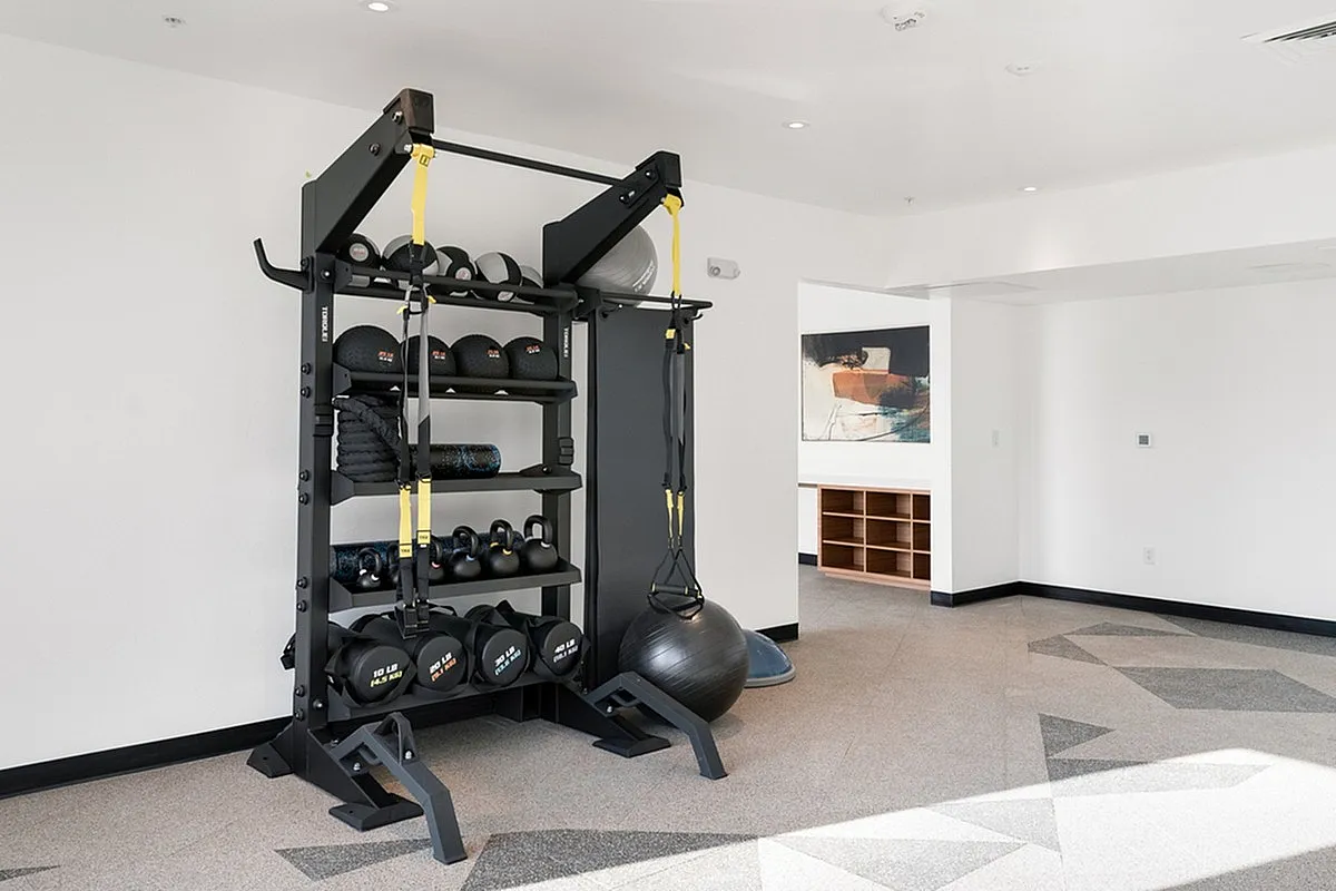 Modern fitness area at Cottonwood Highland Apartments featuring versatile exercise equipment, sleek design, and contemporary furnishings.