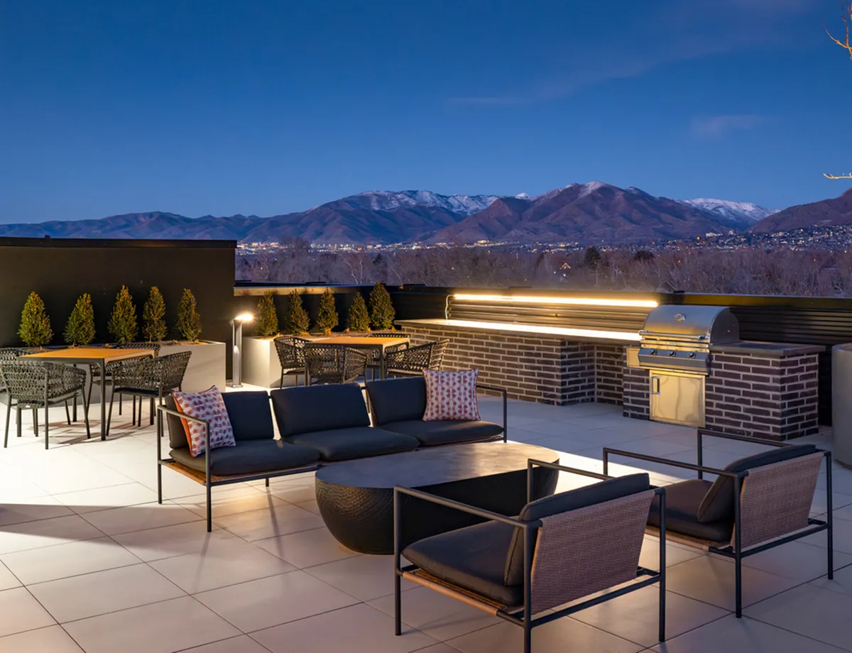 Luxurious outdoor terrace at Cottonwood Highland Apartments with modern seating, ambient lighting, and mountain views perfect for entertaining.
