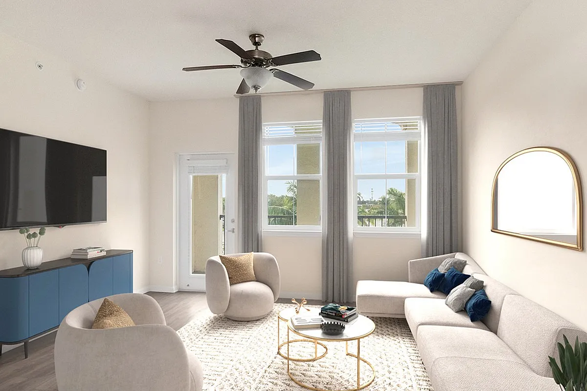 Bright and airy living room at Lighthouse Point Apartments in Pompano Beach featuring elegant furniture, a stylish wall-mounted TV, and large windows with scenic views.