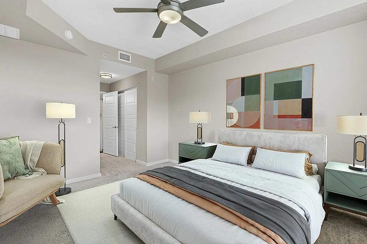 Elegant bedroom with contemporary decor, featuring a plush bed, modern artwork, and cozy seating area.