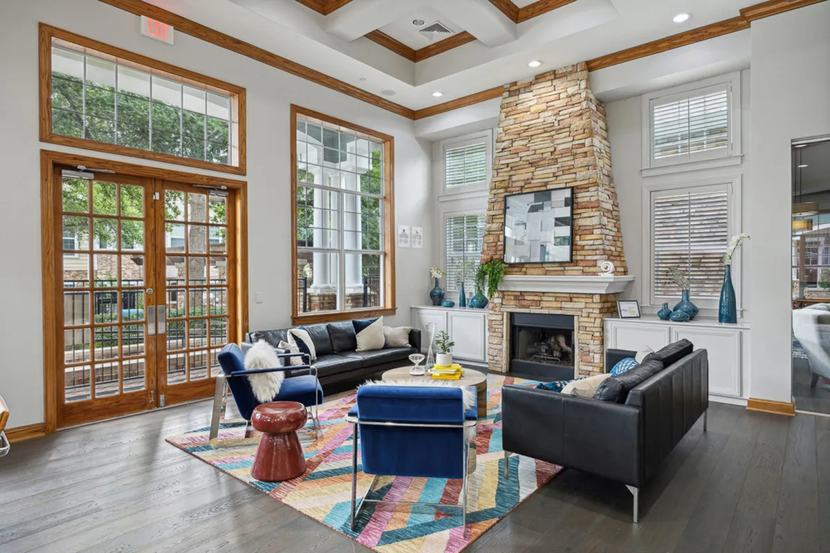 Elegant coworking space at Cottonwood Ridgeview featuring a cozy stone fireplace, large windows, and modern decor with vibrant accents.