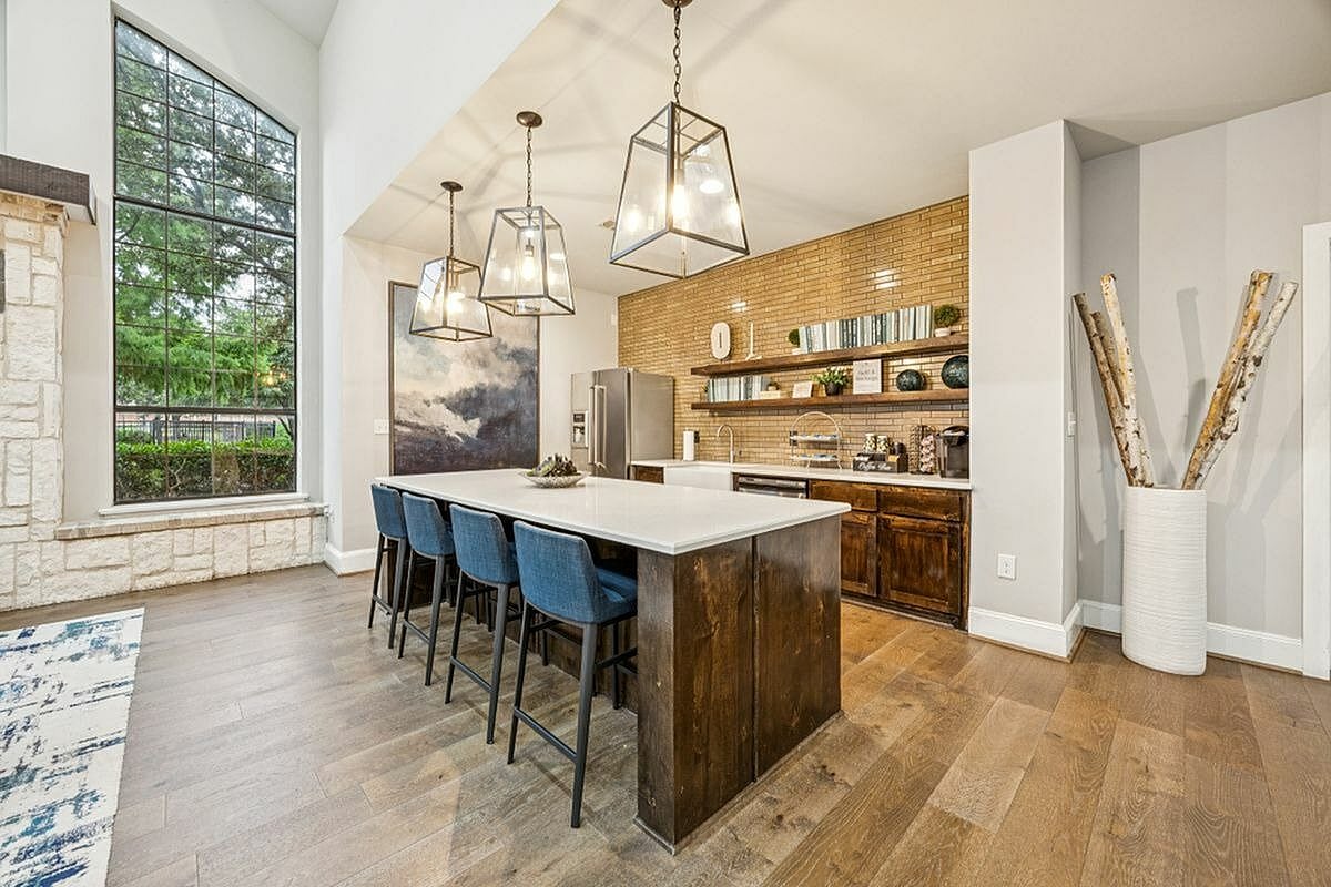Elegant kitchen with large island, modern lighting, and expansive window view at Apt CoWork at Toscana at Valley Ridge Apartments in Lewisville Texas