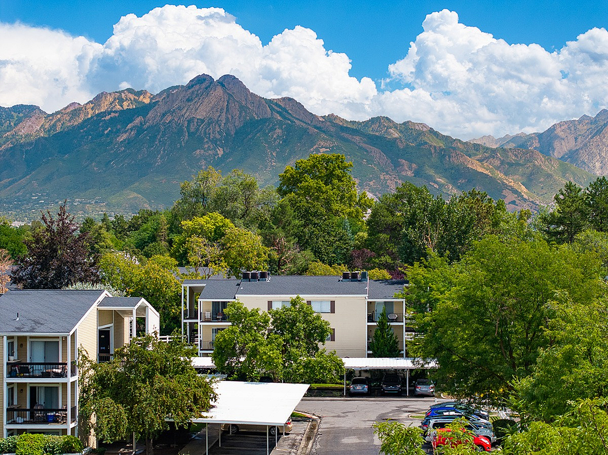 Serene apartment complex, Fox Point in Old Farm, nestled amid lush greenery with majestic Wasatch mountain views.