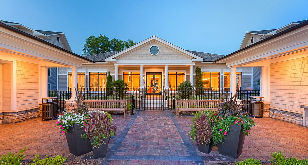 Charming apartment complex entrance, Heights at Meridian, with elegant architecture, glowing warm lights, and vibrant landscaped greenery, creating a welcoming and luxurious ambiance.
