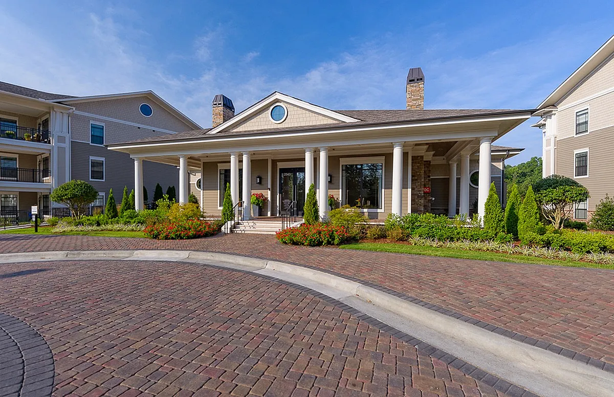 Elegant exterior of Heights at Meridian Apartments with classic columns, lush landscaping, and inviting architecture.