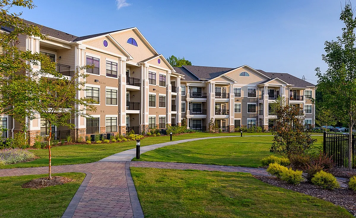 Charming apartment complex, Heights at Meridian, with elegant architecture, surrounded by lush greenery and a welcoming pathway.