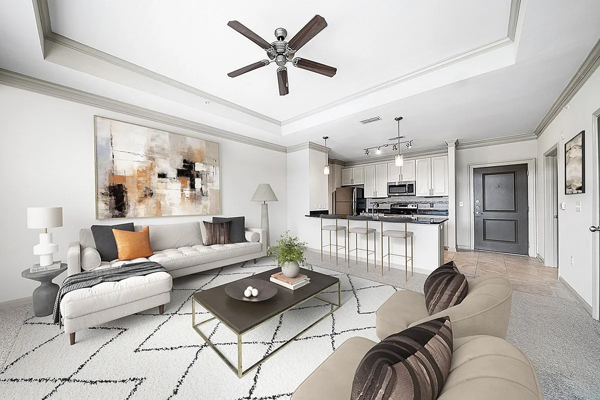 Modern open-concept living room at Heights at Meridian Apartments with elegant neutral tones, stylish furniture, and a sleek kitchen with stainless steel appliances.