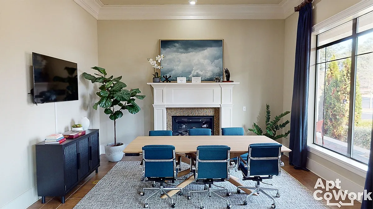 Elegant meeting room at Heights at Meridian Apartments with stylish blue chairs, polished wooden table, and a cozy fireplace under a serene cloud painting.