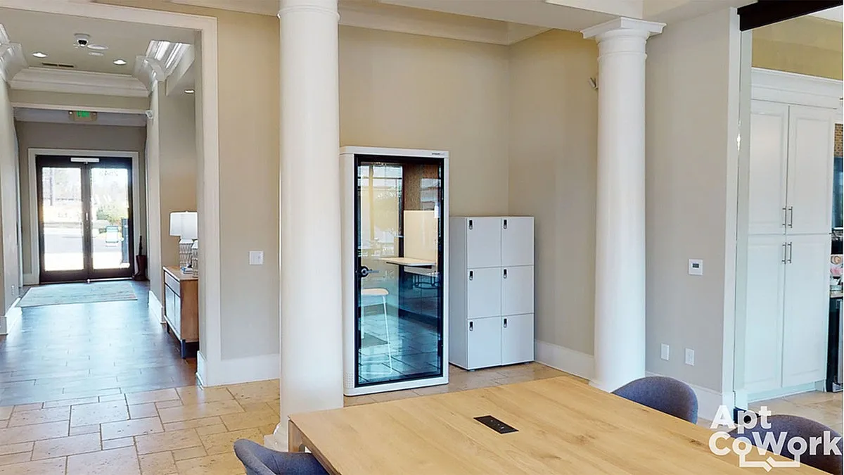 Inviting workspace at Heights at Meridian featuring elegant columns, a modern privacy booth, and ample natural light.