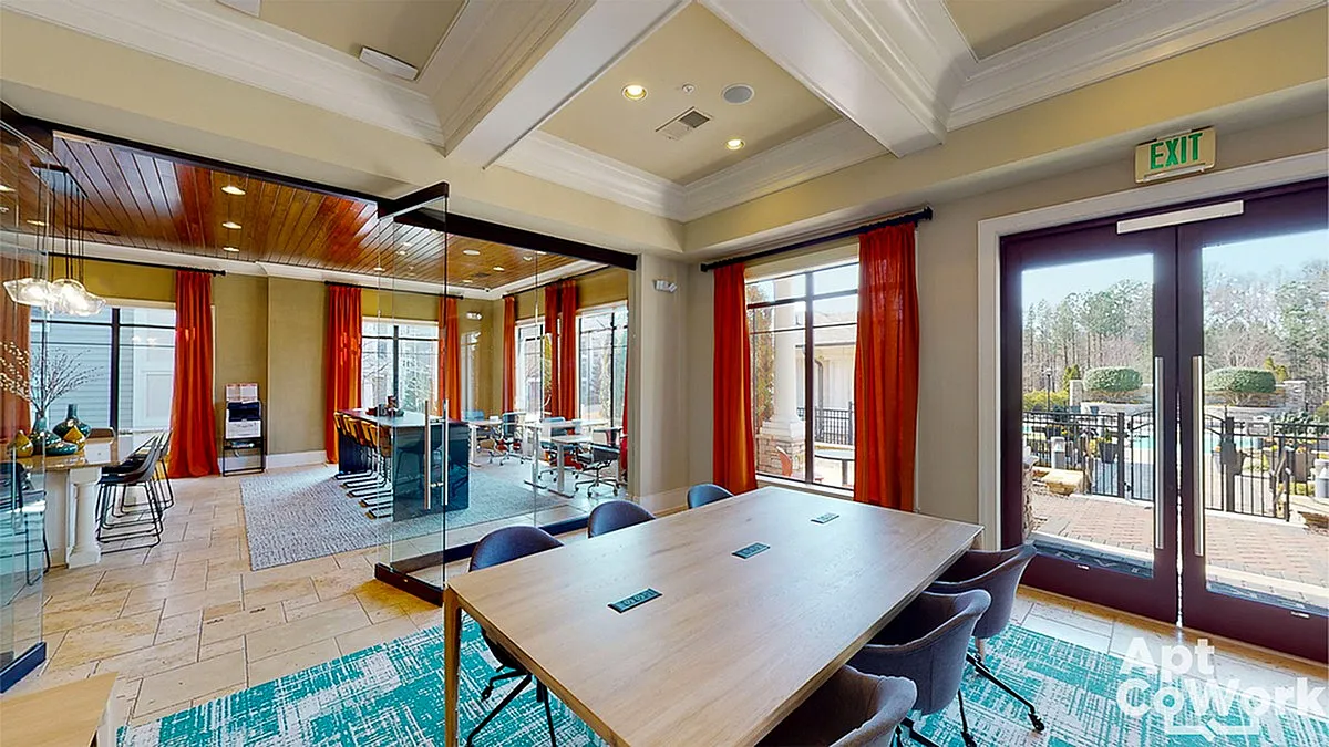 Modern coworking space at Heights at Meridian featuring a glass-enclosed meeting room, elegant decor, and expansive outdoor views.