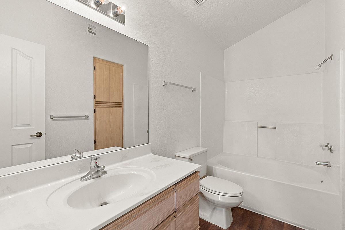 Modern bathroom at Pavilions Apartments with elegant sink vanity, spacious tub, and sleek fixtures in a bright, airy setting.