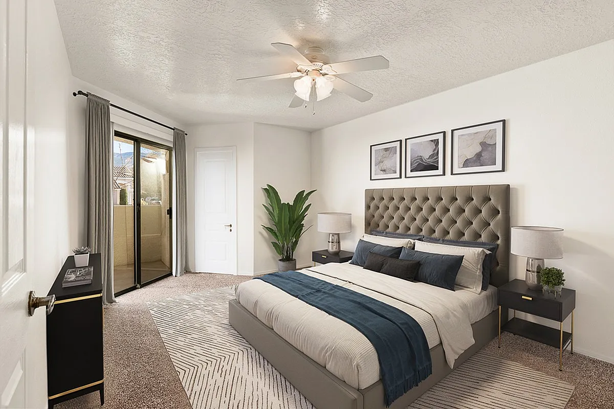 Elegant bedroom at Pavilions Apartments with plush bed, modern decor, and natural light from sliding glass doors.