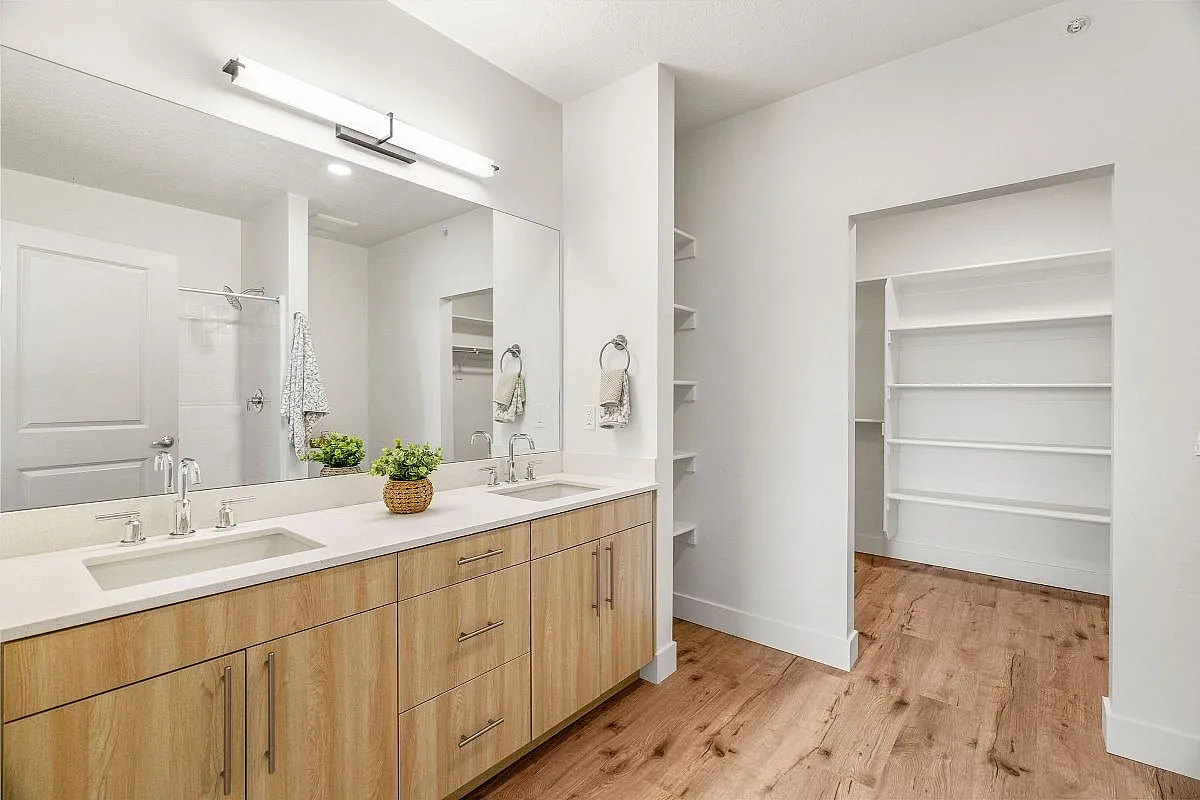 Elegant bathroom featuring a double vanity with sleek fixtures, ample storage, and open shelving for a stylish, modern look at Current apartments in Salt Lake City