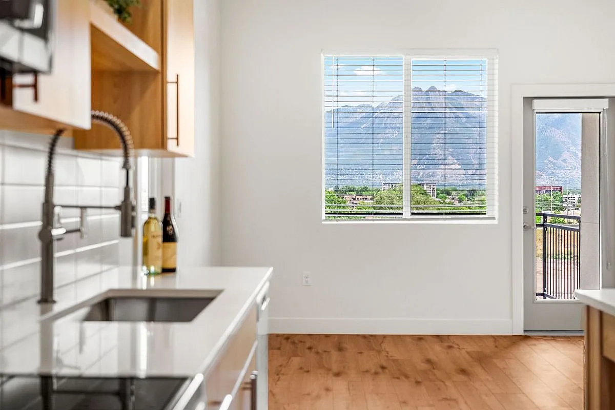 Modern kitchen with sleek countertops and stunning mountain view from the window, offering a perfect blend of style and natural beauty at Current Apartments in SLC