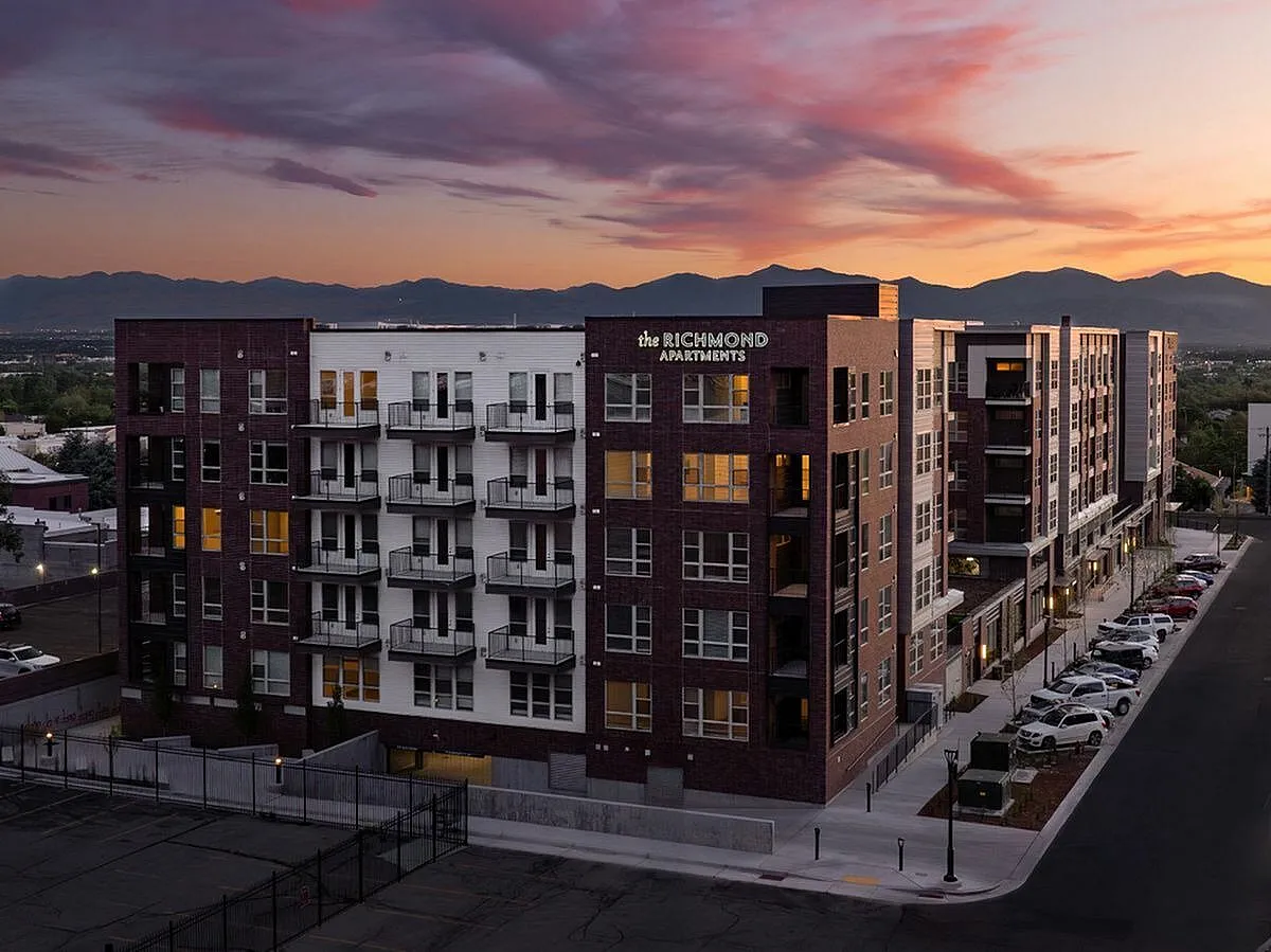 Stunning sunset view of The Richmond Apartments with modern architecture and vibrant cityscape backdrop at The Richmond Apartments in Millcreek