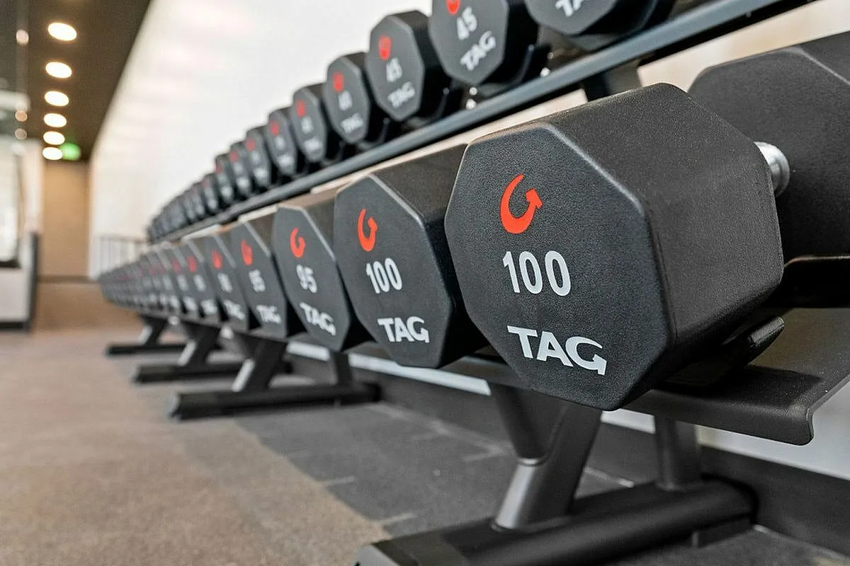 Free weights in fitness center with neatly organized free weights on a sleek rack, perfect for strength training at The Richmond Apartments in Millcreek Utah